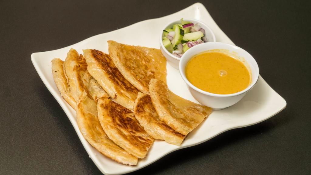 A2. Roti And Kari (2 pcs) · Pan-fried layered flat bread served with a side of curry sauce & cucumber salad.