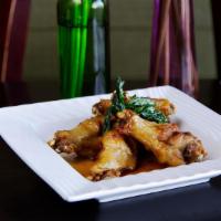 Chicken Wings · Fried chicken wings and glazed with our sweet and spicy sauce with crispy basil.