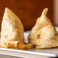 Samosa · Vegan. Two crispy puff pastries filled with potatoes and peas.