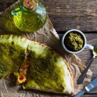 Pesto Calzone · Grilled chicken, mushrooms, onions, pesto sauce with mozzarella cheese stone-baked, with a s...