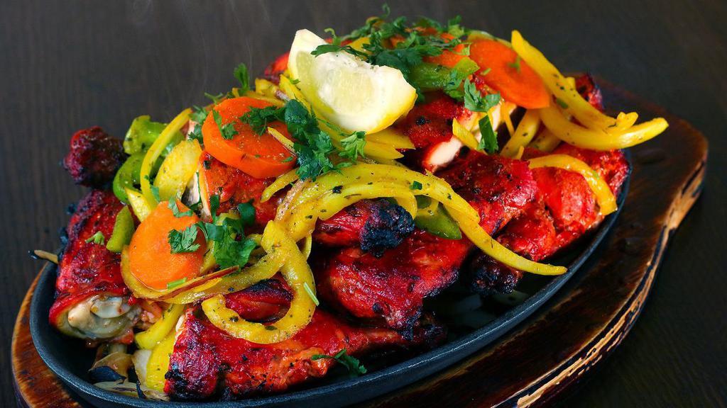 Tandoori Chicken · Char grilled chicken (on the bone) marinated in yogurt, ginger, garlic and spices.