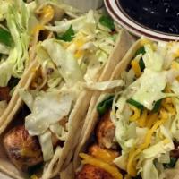 Fish Taco · Made with Fresh Salmon. Topped with mix salad, Cheddar cheese, green onion, and chipotle sau...