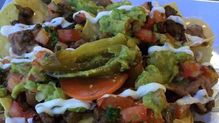 Oscar's Nachos with Meat · Choice of meat with refried beans, jack cheese, sour cream, pico de gallo, freshly made guacamole and jalapenos.