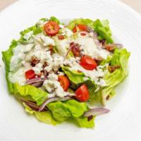 Insalata Burro · Organic living butter lettuce, cherry tomatoes, onions, blue cheese, and blue cheese crumble