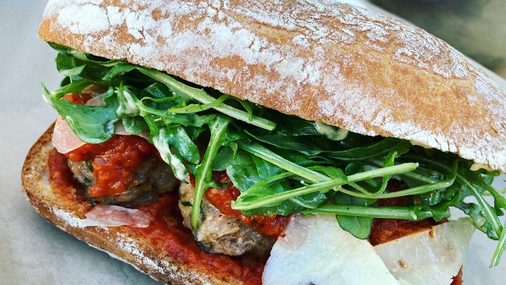 Hot Meatball Sandwich  · Housemade beef and pork meatballs with tomato sauce, manchego cheese, arugula, and aioli.