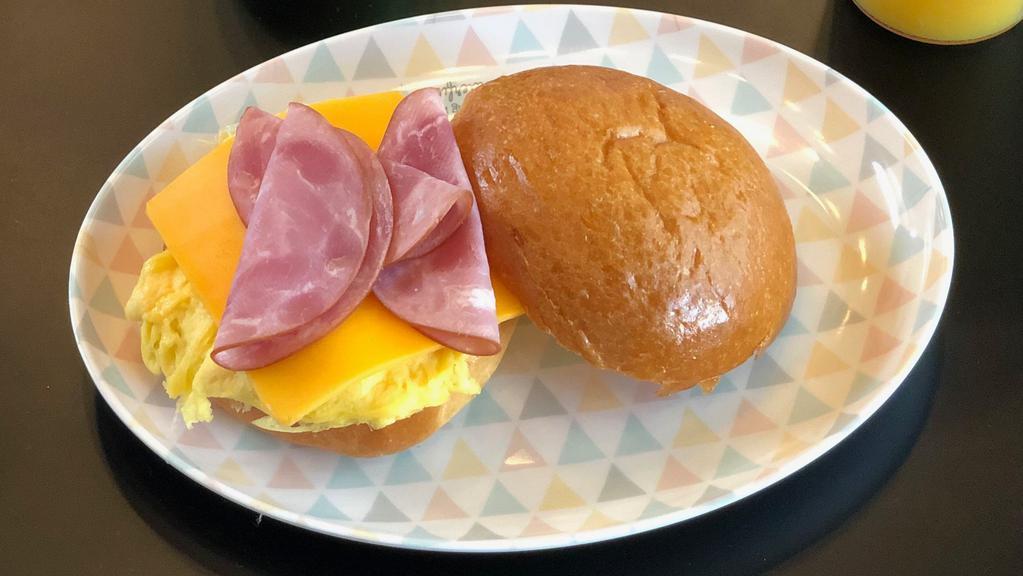 Egg , Ham & Cheddar Breakfast Sandwich · Two eggs scrambled, ham, melty Cheddar cheese on a brioche bun.