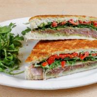 Prosciutto Panini · Aged prosciutto, basil pesto, provolone cheese, roasted bell peppers with fresh greens on fo...