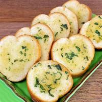 Garlic Bread · Toasted baguette brushed with butter and seasoned with our house-made garlic blend.