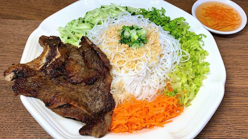Grilled Pork Chop Vermicelli · Grilled, house-marinated pork chop on a bed of vermicelli noodles and sliced vegetables. Served with Vietnamese fish sauce and crushed peanuts (unless specified elsewise in the comments).