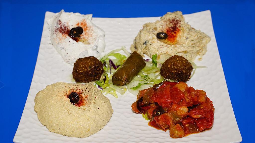 11. Appetizer Combo · Hummus, Baba Ganoush, Dolma, Cacik, Falafel, and Sautéed Eggplant.
