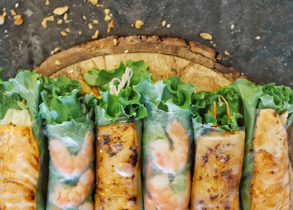 Grilled Salmon Rolls · 4 PC grilled salmon belly and vermicelli noodles wrapped with fresh herbs in rice paper. 
Served with crushed peanuts and ginger wasabi aioli or fusion fish sauce.