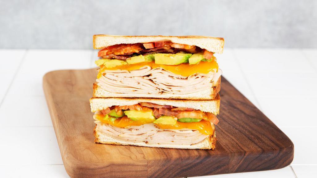 Turkey Club · Griddled sandwich with turkey, bacon, melty yellow cheddar, tomato, avocado, mayonnaise, and your choice of bread.