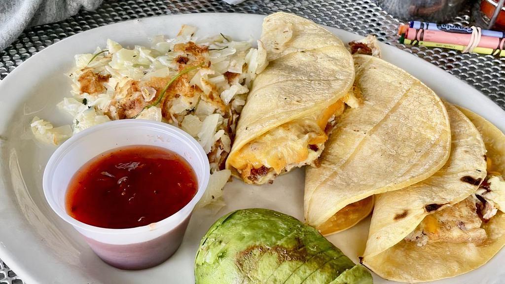 Bacon & Eggs Tacos · 3 corn tortillas filled with bacon and scrambled eggs, topped with cheddar cheese and garnished with avocado. Served with salsa, fruit cup, and potatoes. May substitute chorizo for bacon.
