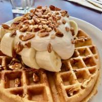 GF Banana Pecan Waffle · Filled with roasted pecans, topped with sliced bananas and fresh whipped cream.