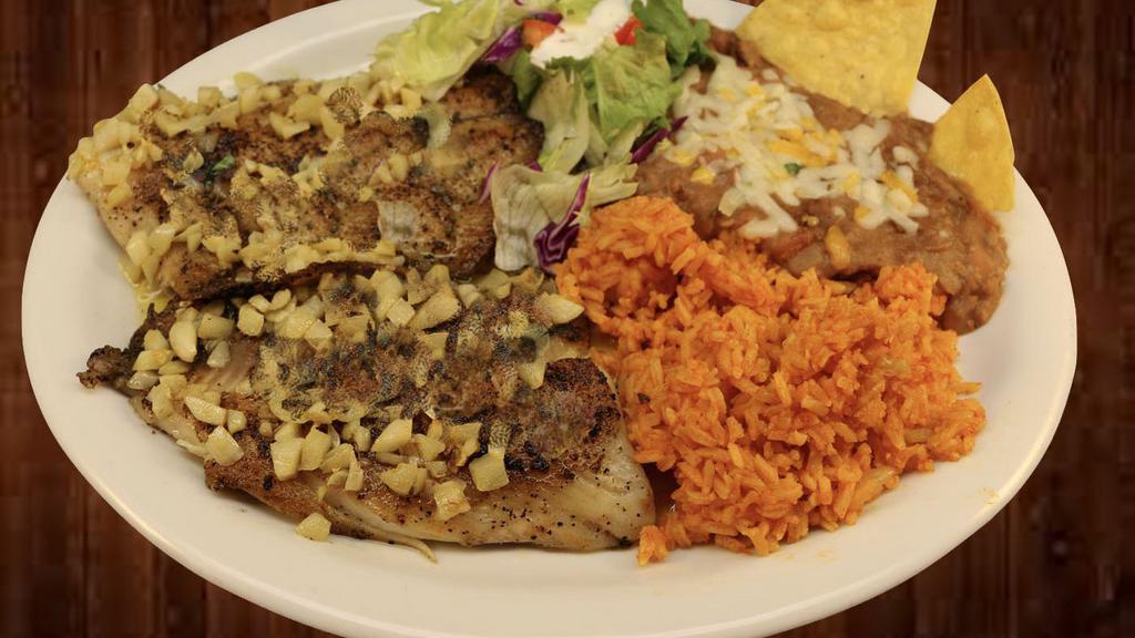 Pescado Al Mojo De Ajo · Fish in chunks of garlic with butter. Rice, beans, and corn tortillas on the side.