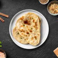 Onion Naan · Freshly baked bread in a clay oven garnished with onions.