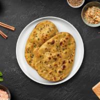 Aloo Naan · Freshly baked bread in a clay oven garnished with potatoes.