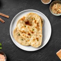 Sweet Naan · Freshly baked bread in a clay oven garnished with sugar, coconut, & raisins.
