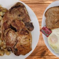 Two Pork Chops and Eggs · Served with two eggs, potatoes, buttered toast, and jam.