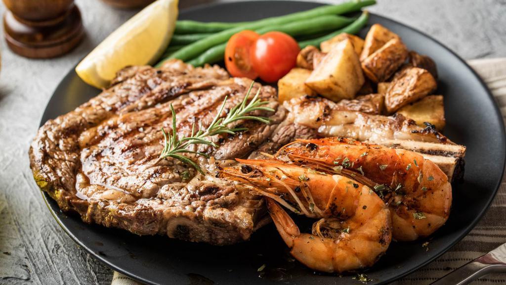 Ribeye Steak with Prawns · A mouthwatering 10 oz Grilled Ribeye Steak seasoned to perfection with 4 prawns. Served with a side of Rice, beans, side salad, and homemade tortillas.