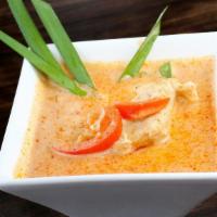 Red Curry (Kaeng Dang) · Red curry paste in coconut milk, bell peppers, bamboo shoots, and basil leaves.