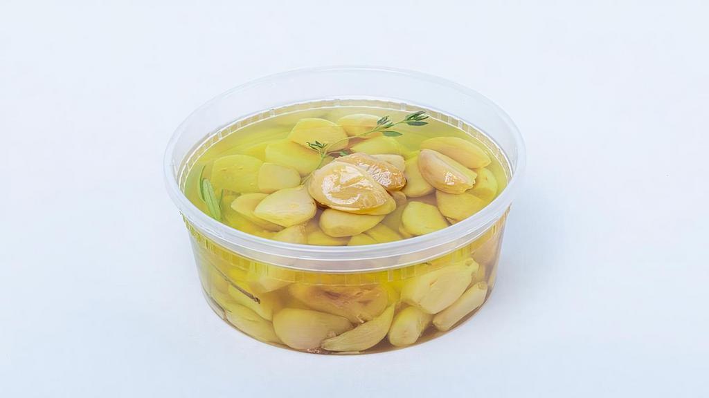 Garlic Confit · Whole garlic cloves and fresh herbs slowly cooked in olive oil.