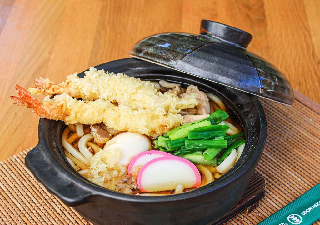 Nabe Yaki Udon · Soft boiled egg, shrimp tempura, chicken, onions, kamaboko (fishcake), maitake, green onions cooked in a clay pot.