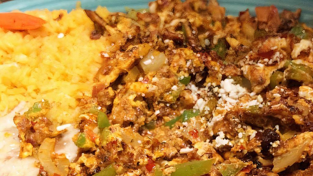 Huevos Con Chorizo · Two eggs scrambled with Mexican sausage mixed tomatoes, onion, bell peppers topped with dry cotija cheese, served with rice, beans & tortillas.