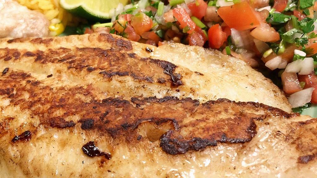 Filete a La Plancha · Grilled fish fillet - served with rice, choice of pinto, black or refried beans, salad and tortillas.
