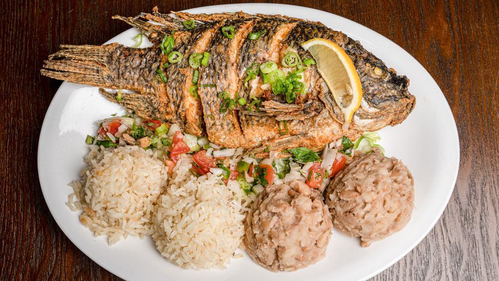 Mojarra · Whole bone in tilapia seasoned and deep fried served with white rice and beans