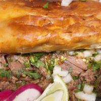 Torta Ahogada · Traditional telera, carnitas, smoother on spicy red sauce, onion and vinegar.