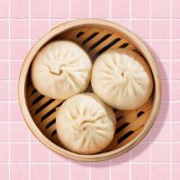 Steamed Buns · Six steamed buns with dipping sauce.