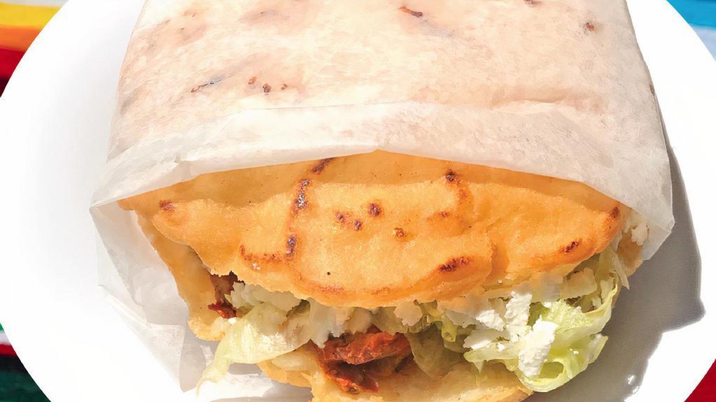 Gordita · Mexican style pita with corn flour stuffed with your choice of meat. Comes with lettuce, onions, cilantro, sour cream, and cheese. This menu item offers Tinga meat (shredded chicken and onions in a chipotle sauce).