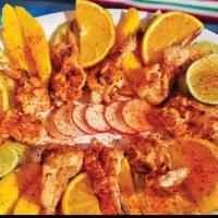 Botana Palacios · Spicy shrimp served with slices of mango, orange, and cucumber.