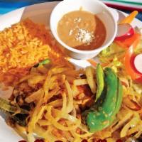 Pollo Encebollado · Grilled chicken covered in grilled onions served with rice, beans, salad, and tortillas.