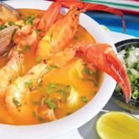 Sopa De Mariscos · Seafood soup with large clams, fish, octopus, and imitation crab. Served with tortillas on t...