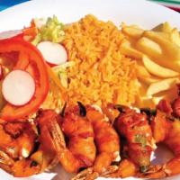Camarones Envueltos · Shrimp wrapped in bacon, jalapeño, and cheese. Served with rice, salad, and French fries.