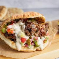 Pita Beef Kebab · Ground beef and lamb kebab, hummus, cucumber, tomato, pickles, and tahini