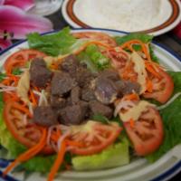 62. Cube Beef Steak · Saute filet mignon served over a bed of green salad or white vermicelli noodles and vegetabl...