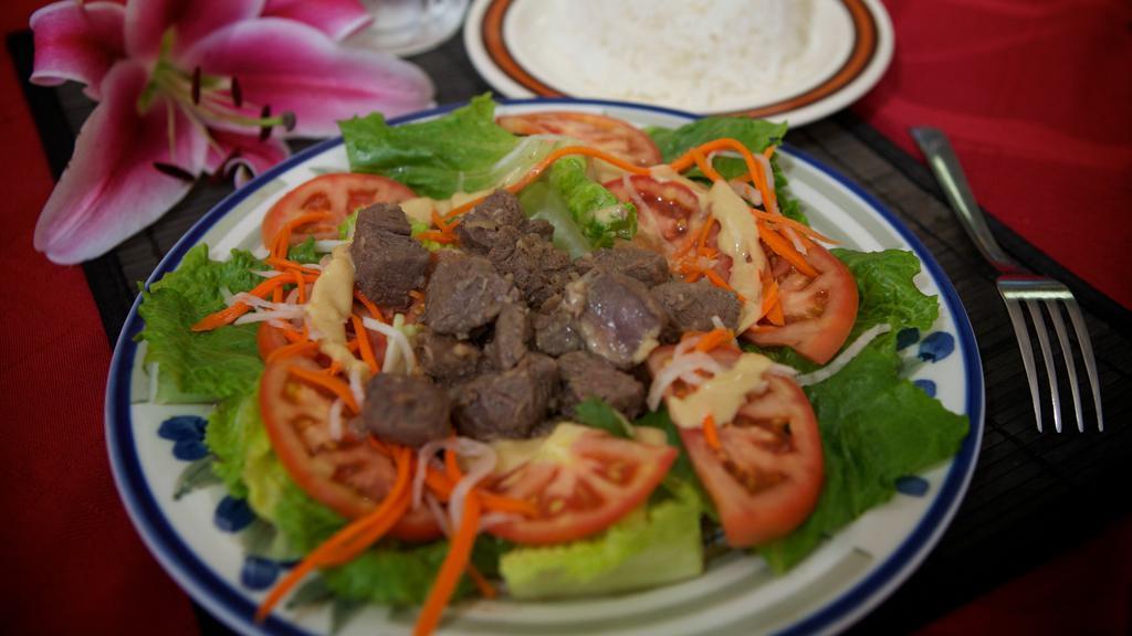 62. Cube Beef Steak · Saute filet mignon served over a bed of green salad or white vermicelli noodles and vegetables.