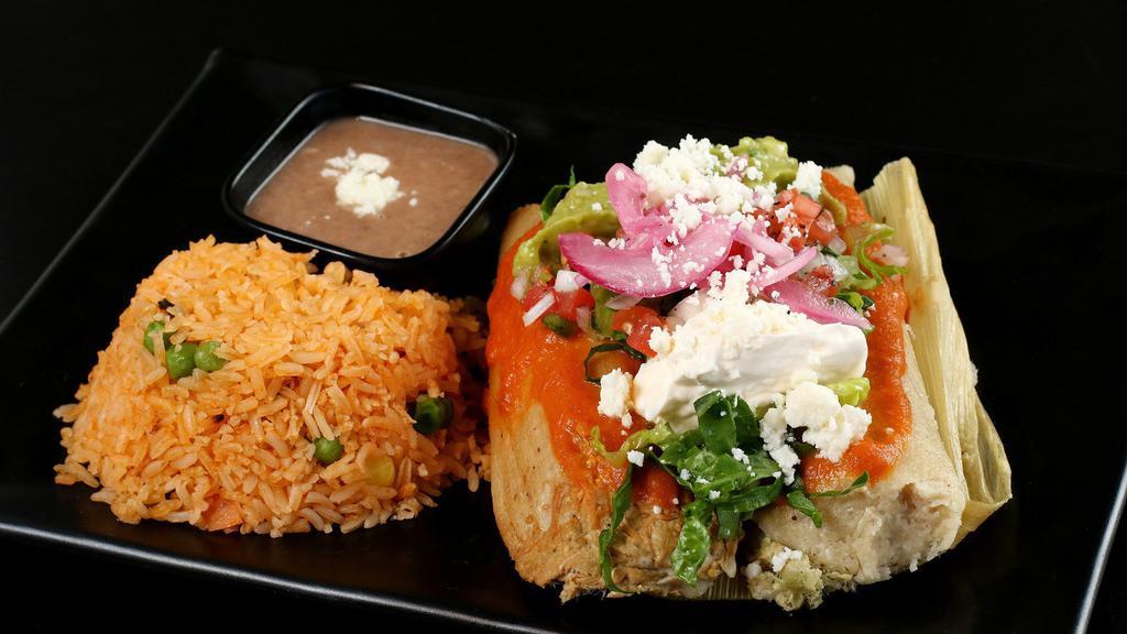 Tamales de Pollo (2 Pieces) · Mexican tamales plate with chicken, cheese, guacamole, salsa, and crema.  With choice of rice & beans or side salad