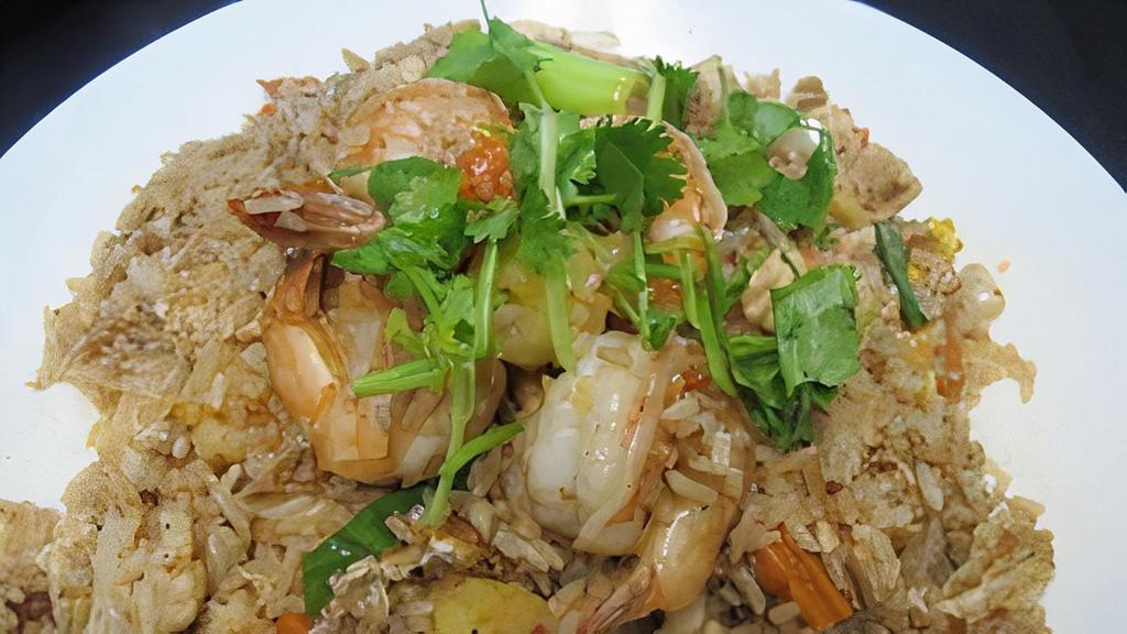 Pineapple Fried Rice · Thai-style fried rice deliciously prepared with shrimp, chicken, egg, yellow onion, carrots, baby corn, green onion, and pineapple.
