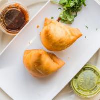 Samosas · Spicy. Vegetarian. Crispy puffs filled with potatoes and green peas.