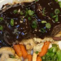 Braised Short Ribs · Served over garlic mashed potatoes with sauteed spinach, onions and peppers