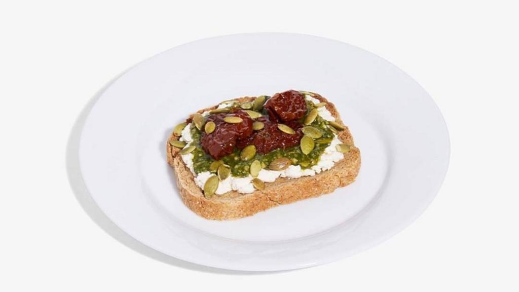 Pesto Toast. · Supergreens pesto, sun dried tomatoes, almond ricotta, toasted pumpkin seed, GF bread.