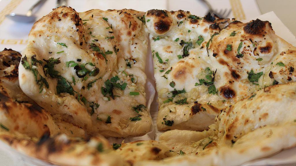 Garlic Naan · Traditional naan topped with chopped garlic and cooked in the tandoor.