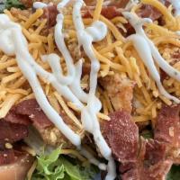 Crispy Chicken Salad · A salad with crispy chicken tenders on a bed of spring mix topped with a blend of Cheddar ch...