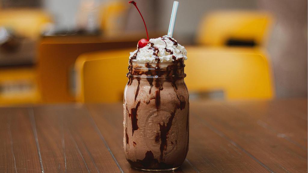 Chocolate Milkshake · Chocolate milkshake topped with whipped cream and a cherry