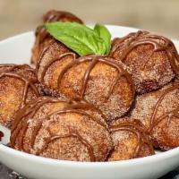 Churritos · Donut Holes made in house from scratch tossed in Cinnamon Sugar finished with a Nutella driz...