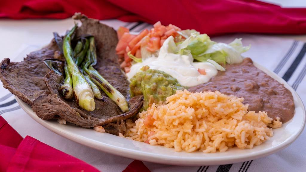 Carne Asada Grilled Steak Platillo · With rice, beans, lettuce, tomatoes, guacamole, sour cream and tortillas.